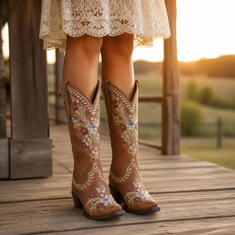 The Embroidered Western Boot in Brown, worn on a porch