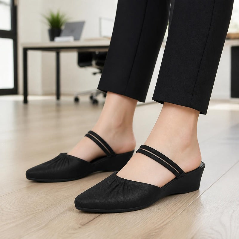 The Pointed Wedge Mule in Black, worn at the office